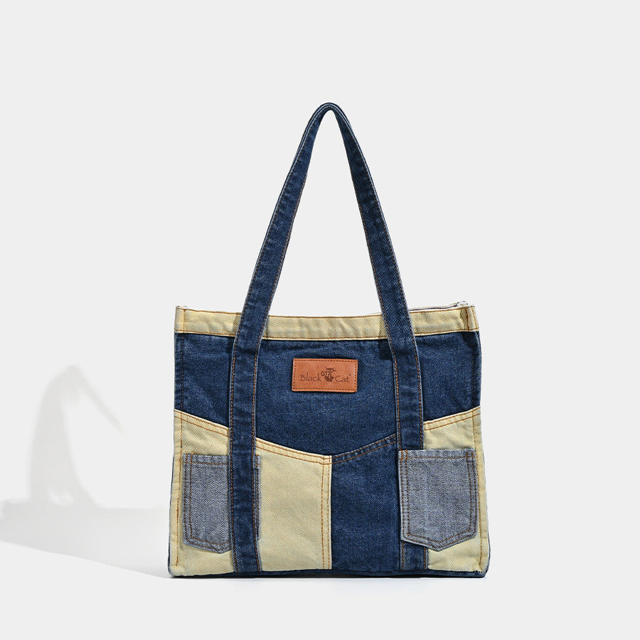 Indigo and khaki denim patchwork tote bag with exterior patch pockets and tan logo badge, front view