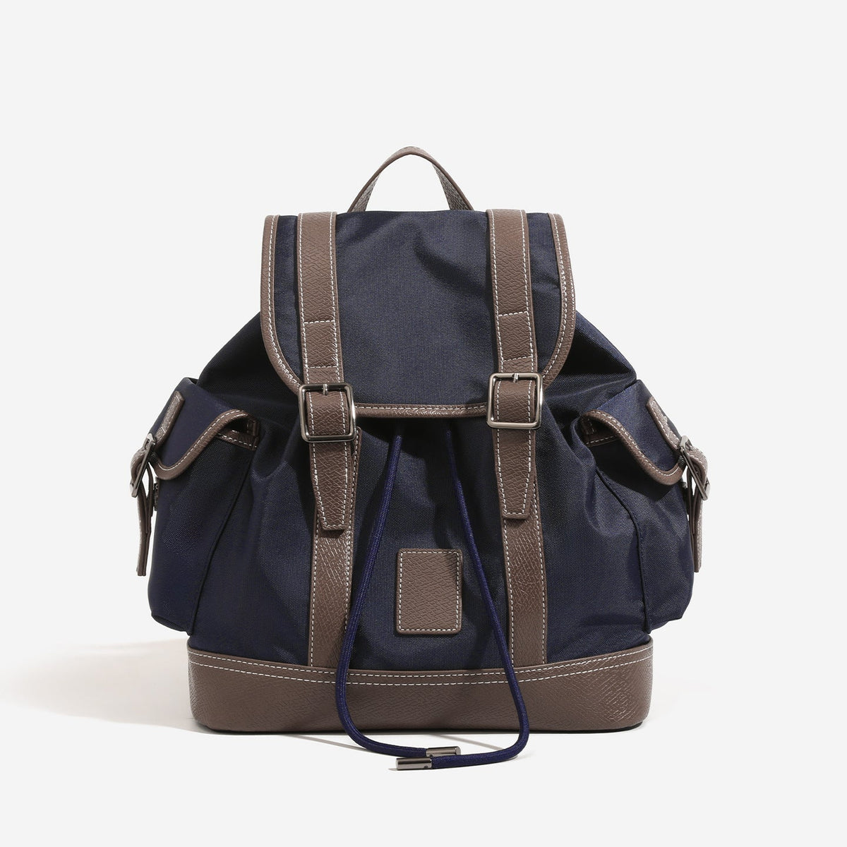 Deep navy canvas backpack with brown textured leather-look trim, drawstring flap closure, buckle-strap front detail, and