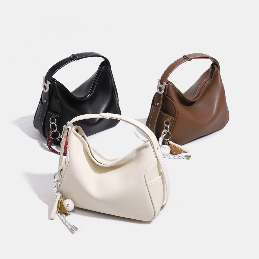 Small soft hobo shoulder bag with zip-top closure, silver-tone U-bar hardware, and sports-themed charm in, detail view 2