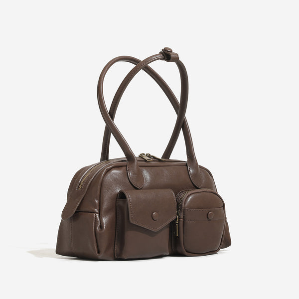 Structured matte leather-look bowling bag with snap-flap and zip front pockets, looped top handles, and antique gold-tone