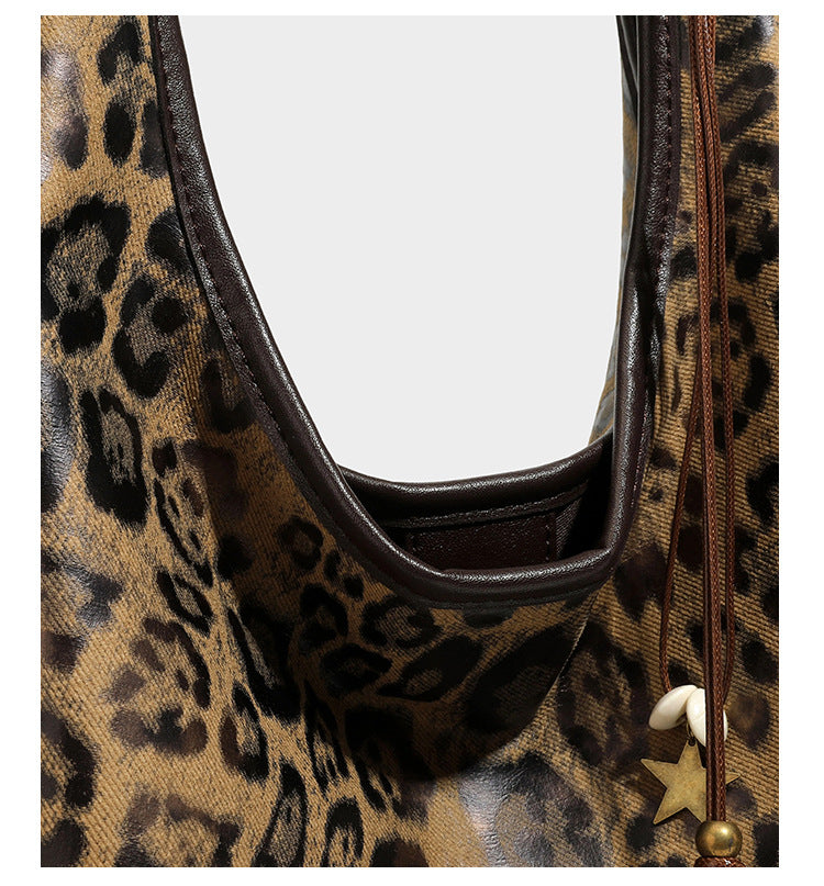 Weich fallende Hobo-Tote-Bag mit Leopardenmuster in Beige und Braun, dunkelbraunem Riemen in Lederoptik und herabhängenden Perlenanhänger-Beschlägen