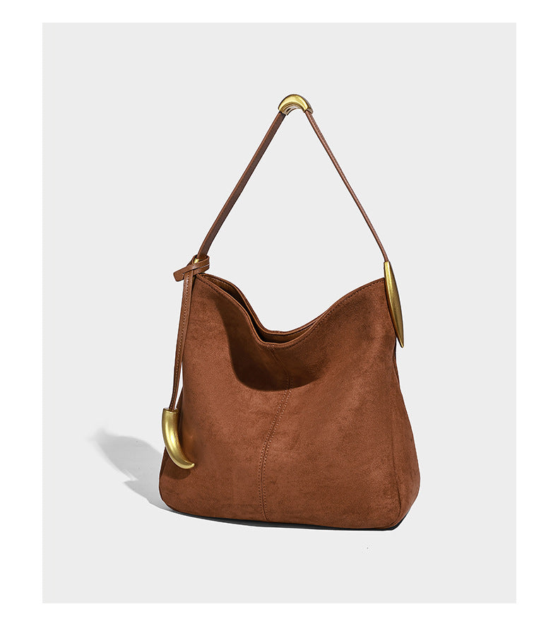 Beige-braune Hobo-Schultertasche mit lässiger Silhouette, matter Veloursleder-Optik, goldfarbenen halbmondförmigen Beschlägen und schmalem Schulterriemen, Detailaufnahme