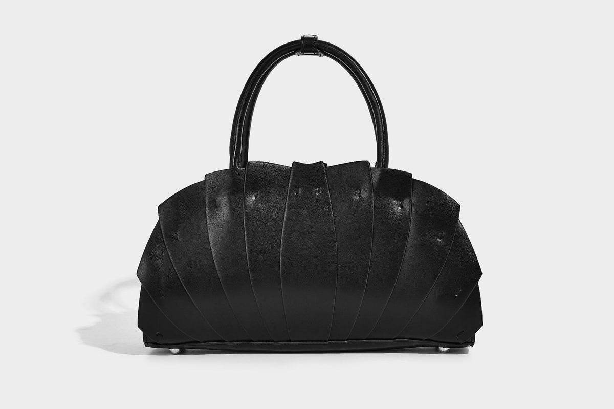Structured dome satchel with fan-pleated leather-look exterior, dual top handles, and detachable shoulder strap, detail view