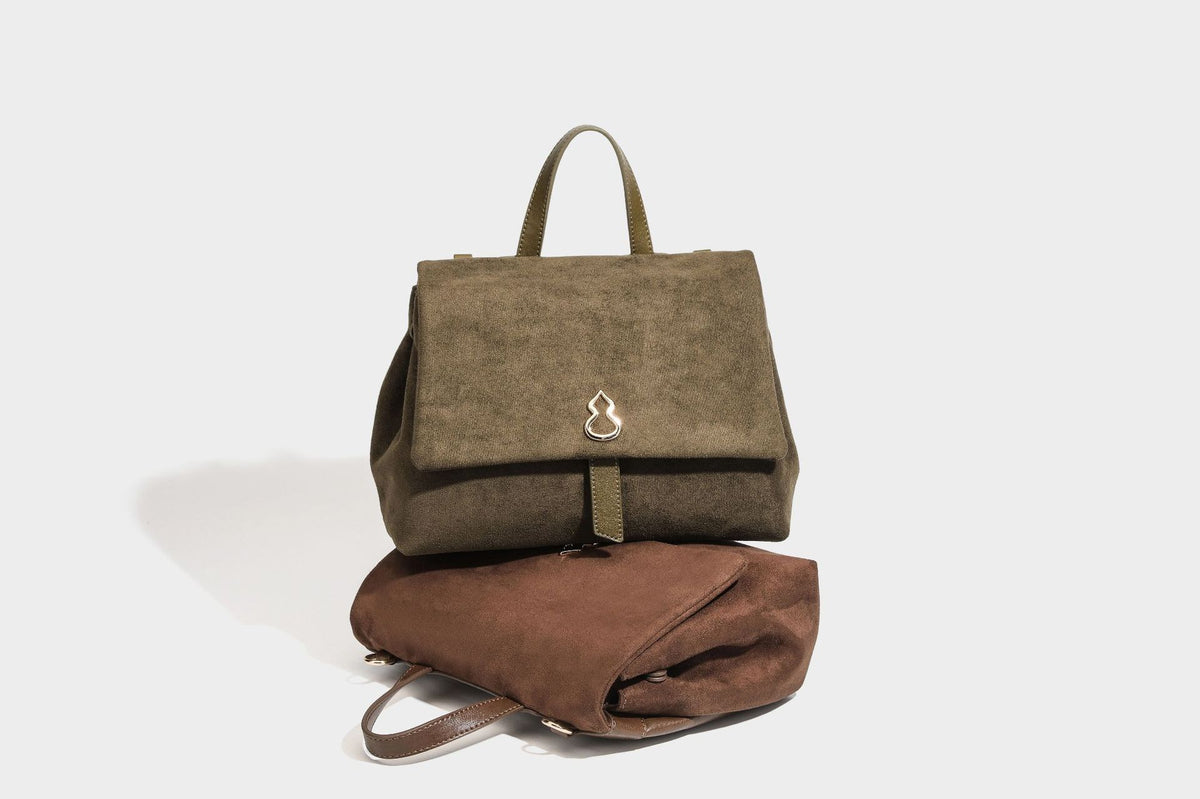 Formstabile Satchel-Tasche mit mattem Veloursleder-Finish, Überschlag, goldfarbenen Emblem-Beschlägen, kurzem Tragegriff und verstellbarem Crossbody-Riemen