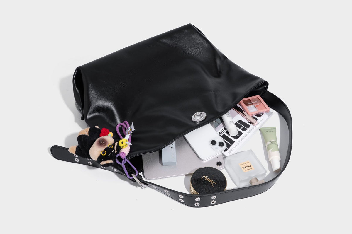 Große schwarze, glänzende Hobo-Schultertasche in Lederoptik mit mit Ösen besetztem Riemen, silberfarbenen Beschlägen und abnehmbarem