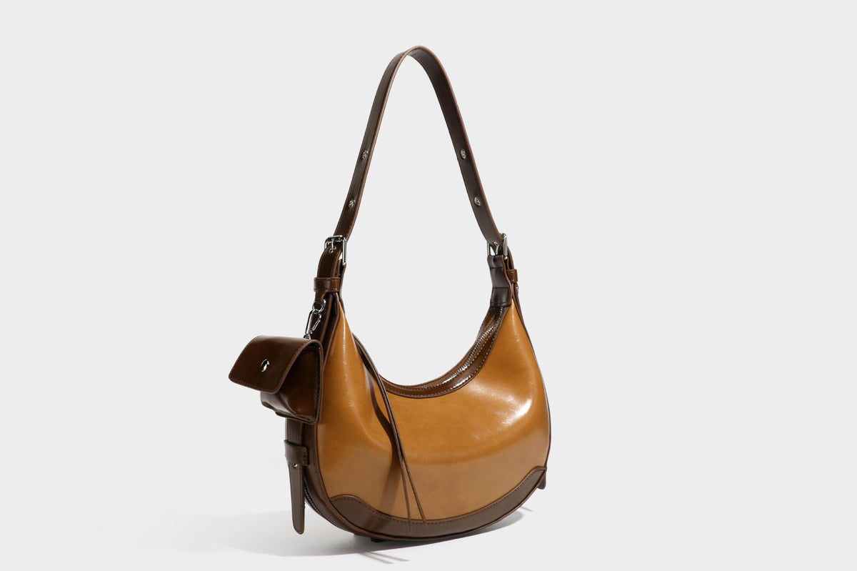 Glossy leather-look crescent hobo shoulder bag with dark contrast trim, silver-tone hardware, and attached mini flap pouch