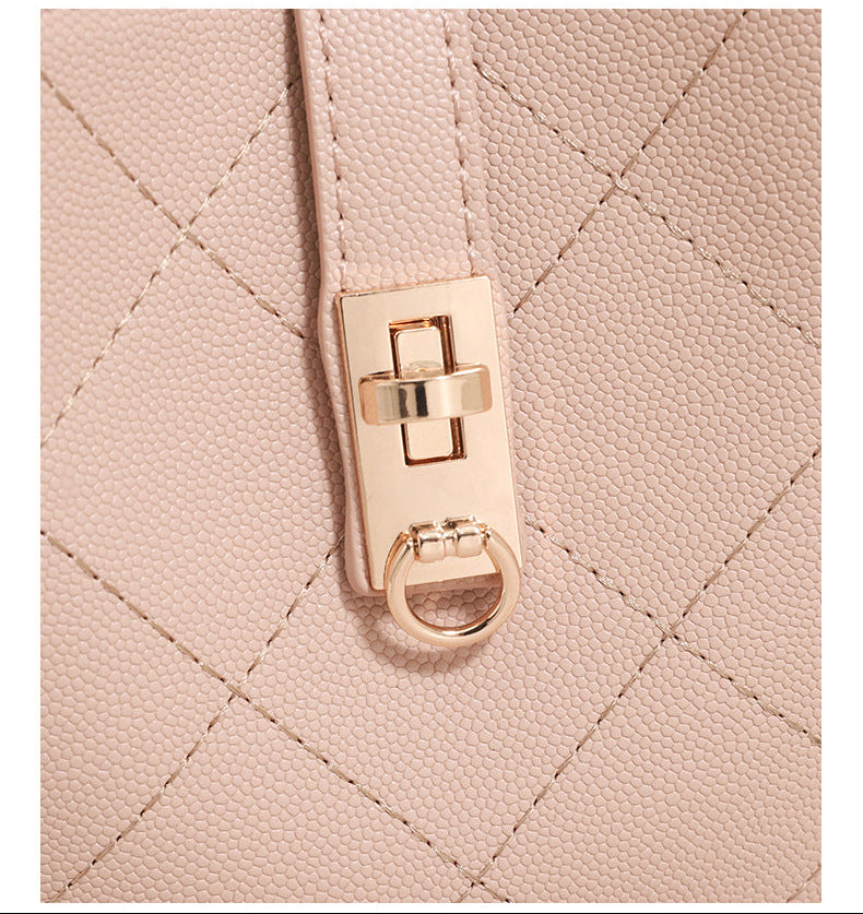 Kleine, formstabile gesteppte Beuteltasche mit Rautensteppung, vorderem Drehverschlussriemen, goldfarbenen Metalldetails und Tragegriff, Detailansicht