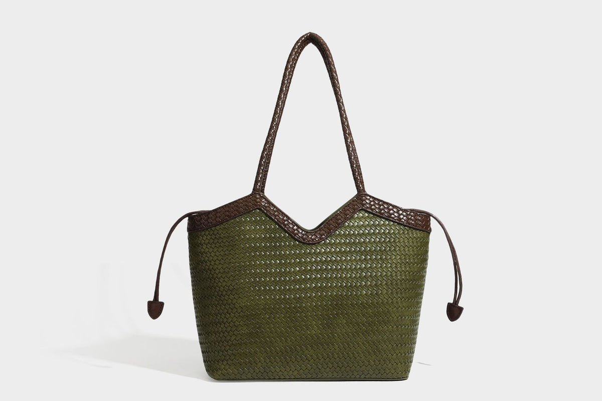 Olivgrüne Tote-Bag in Korbgeflecht-Optik mit dunkelbraunen geflochtenen Schulterriemen, seitlichen Kordelzügen und Perlenanhänger in Goldoptik