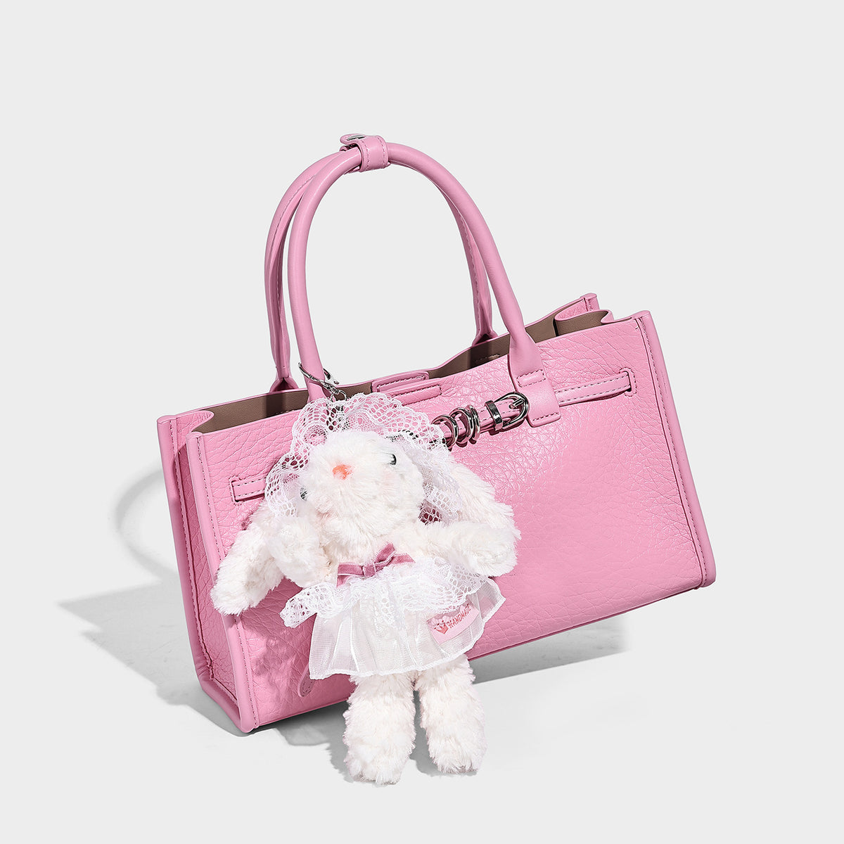 Structured trapezoid tote bag in pebbled leather-look finish with double top handles, silver-tone bar hardware, and, detail