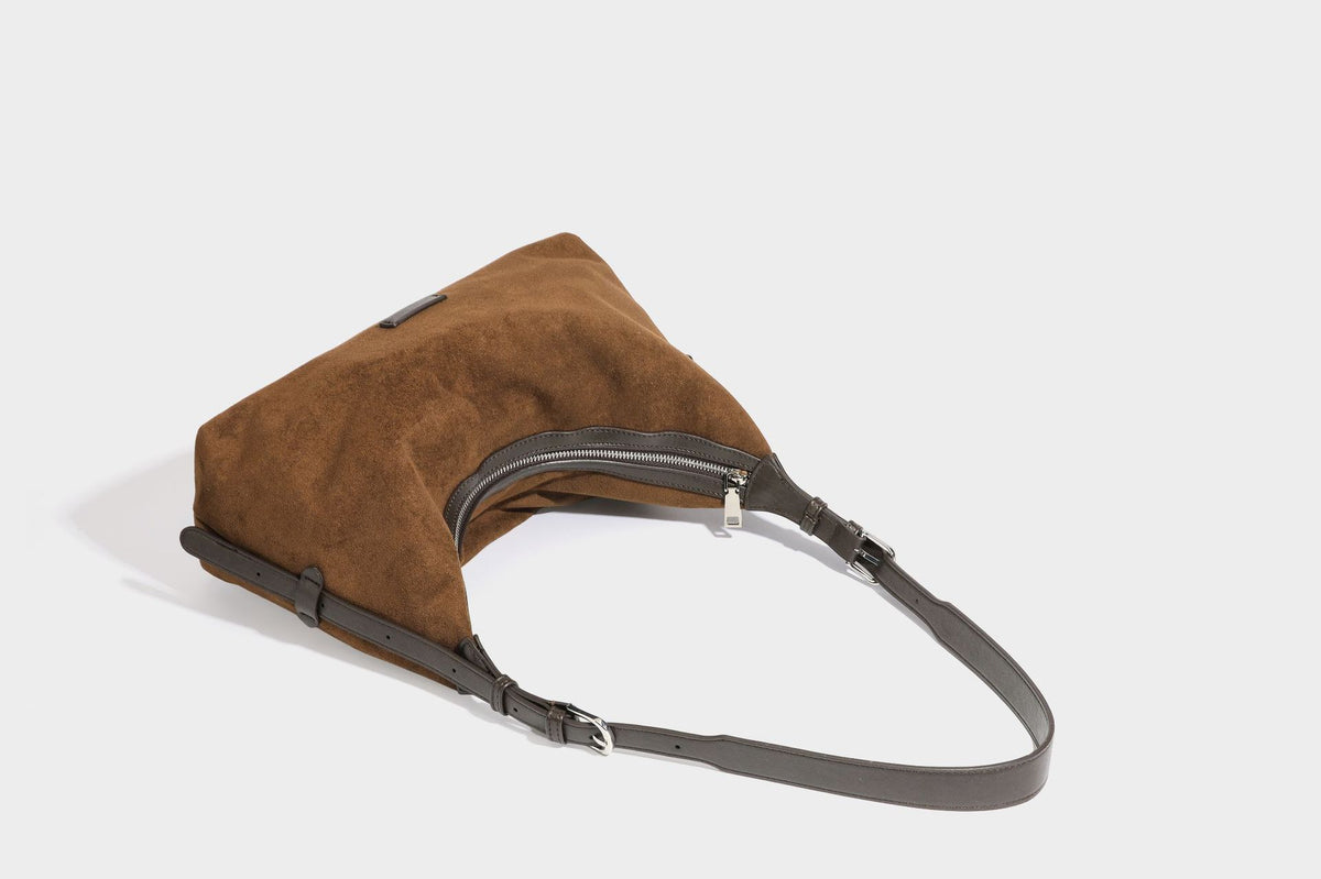 Lässige Hobo-Schultertasche mit matter brauner Wildlederoptik, dunklen glatten Besätzen, Reißverschluss oben und langem, verstellbarem