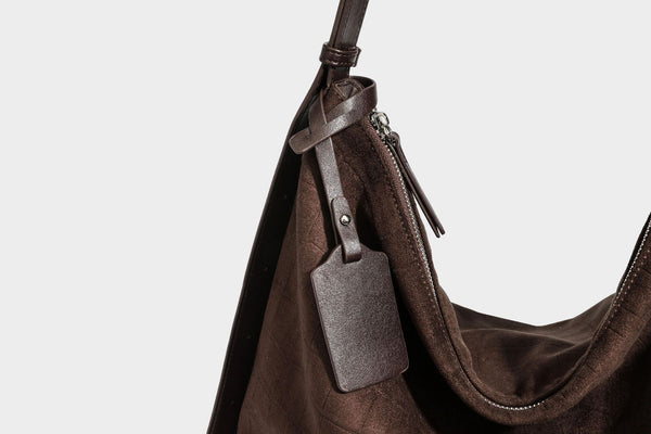 Slouchy hobo shoulder bag in matte croc-embossed leather-look finish with top zip closure and long adjustable strap, detail