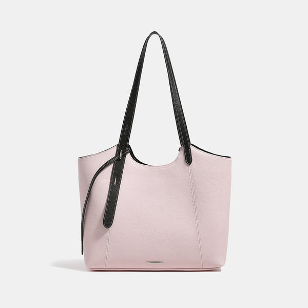 Structured trapezoidal tote bag with smooth leather-look finish, long black contrast shoulder straps, and dangling strap