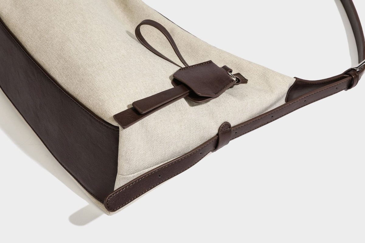 Lässige Hobo-Schultertasche aus haferfarbenem Canvas mit dunkelbraunen Besätzen in Lederoptik, silberfarbenem Reißverschluss und langem, verstellbarem