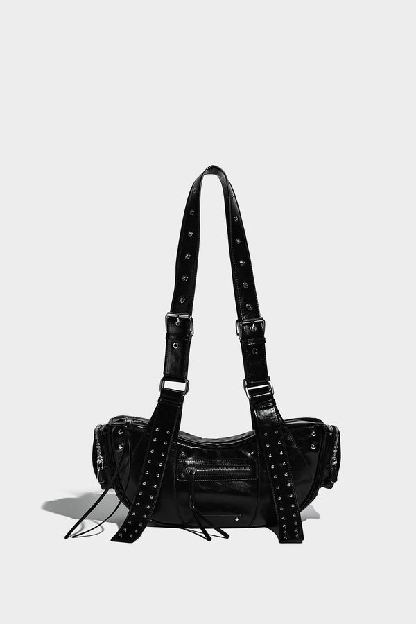 Glossy black crescent shoulder bag with silver-tone rivets, multiple zip pockets, and long adjustable studded straps, detail