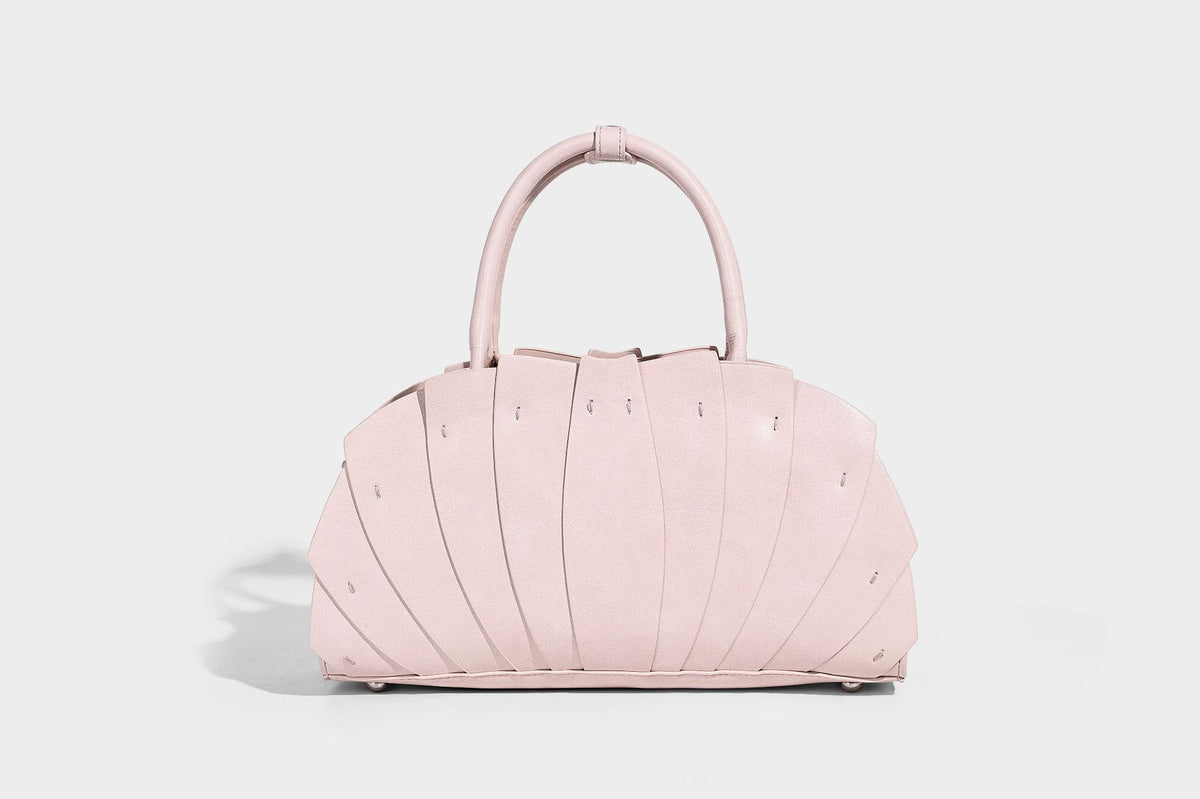 Structured dome satchel with fan-pleated leather-look exterior, dual top handles, and detachable shoulder strap, detail view