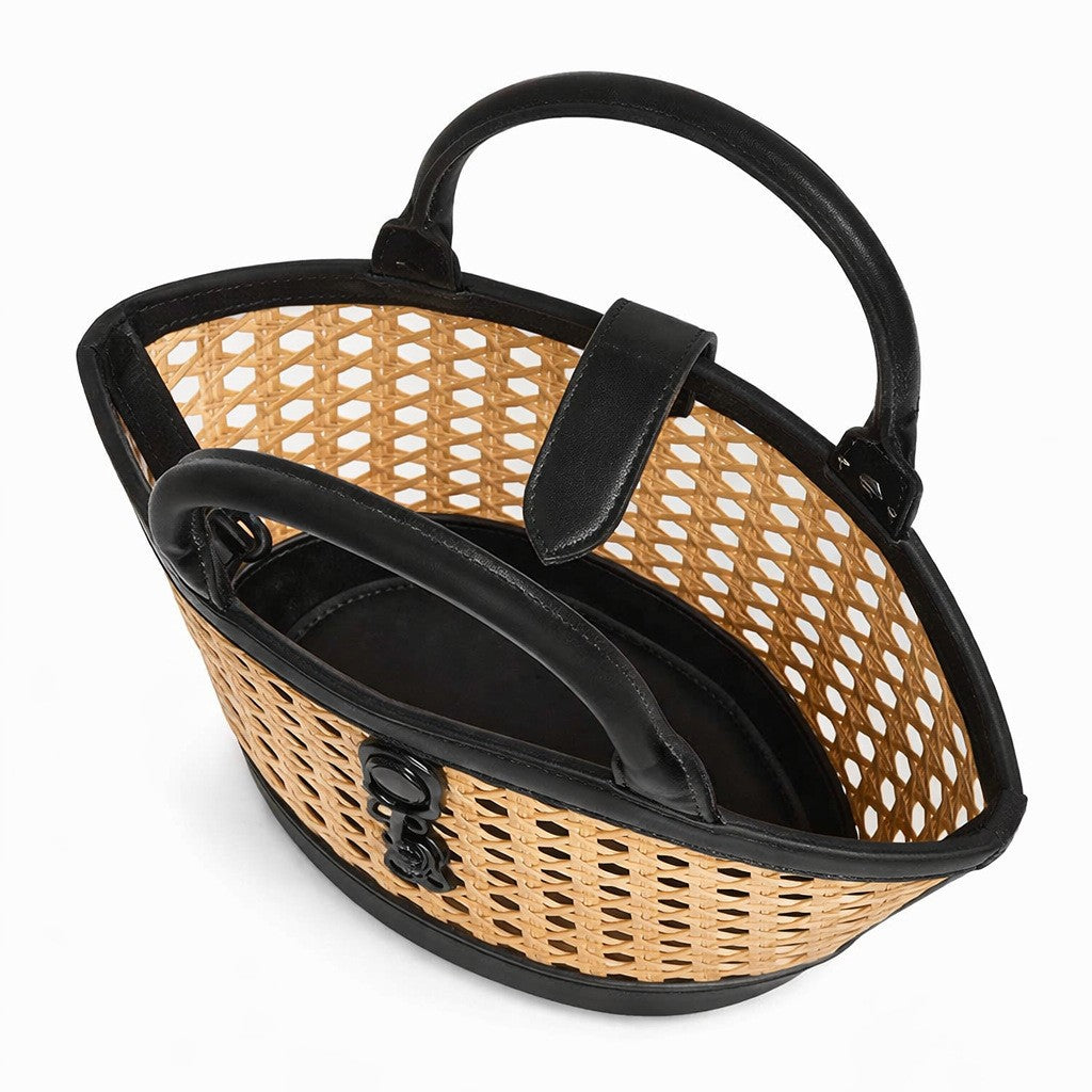 Structured mini tote bag with open-weave rattan body, leather-look arched handles and trim, front tab turn-lock closure, and