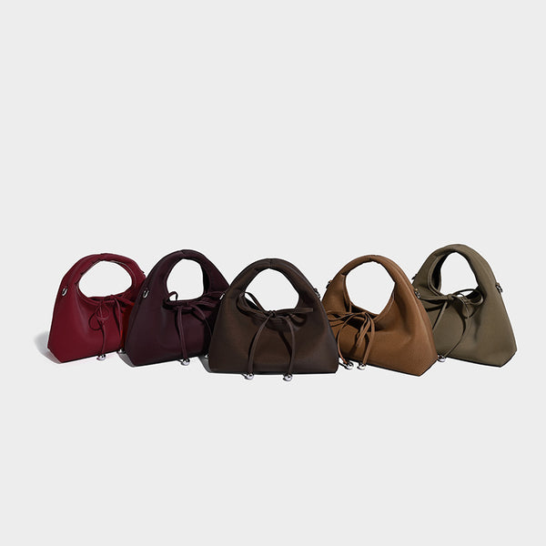 Pebbled matte trapezoid top-handle bag with drawstring bow closure, bead-tipped cords, silver-tone hardware, and detachable