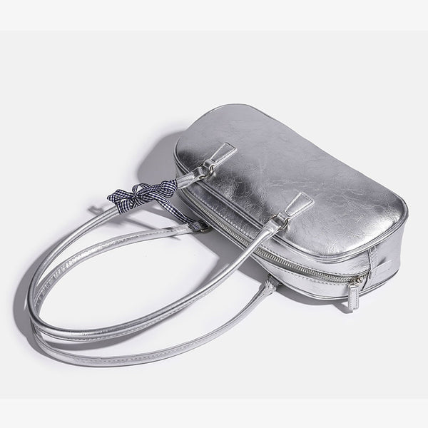 Rounded rectangular shoulder bag with glossy crinkled finish, dual long handles, top zip closure, and gingham ribbon bow