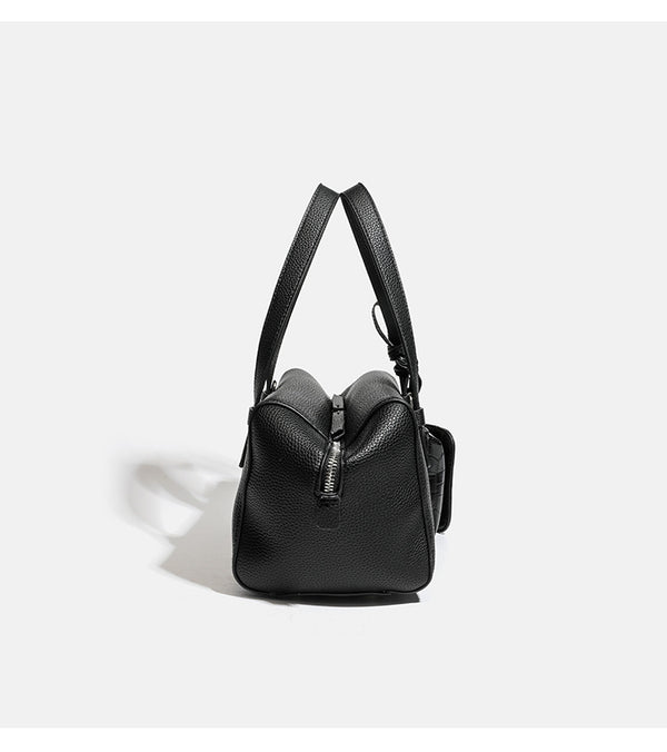 Structured pebbled leather-look top-zip barrel bag with dual handles, detachable shoulder strap, and attached croc-pattern