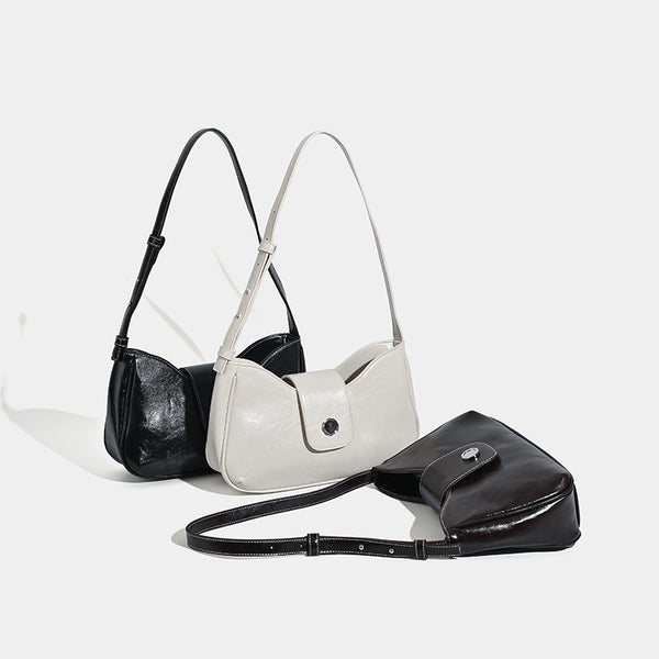 Compact glossy leather-look shoulder bag with round metal snap closure and contrast stitching, detail view 2
