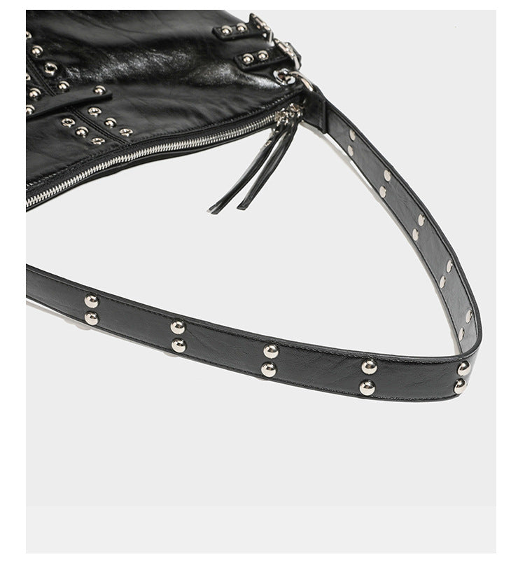 Black glossy leather-look slouchy shoulder bag with silver stud and eyelet hardware, top zip closure, front zip pocket, and