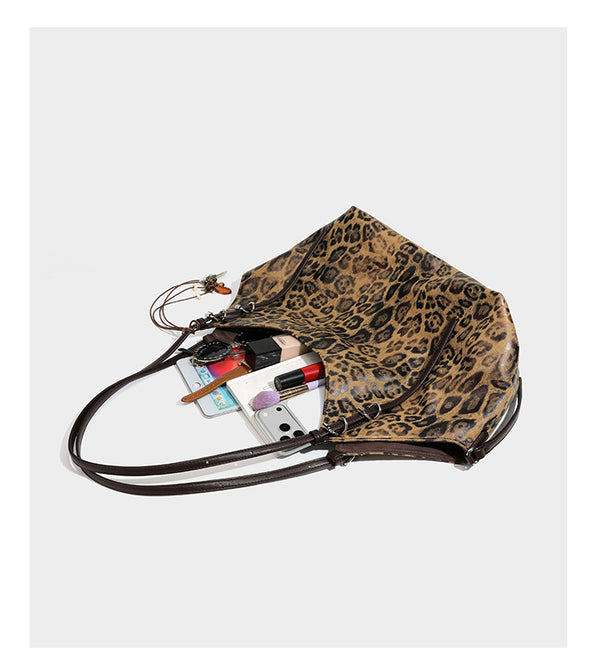 Slouchy leopard-print shoulder tote bag in tan and brown with long double straps, side tie straps, and dangling charm, detail