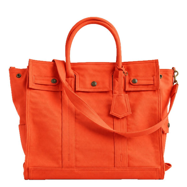 Large washed denim patchwork tote bag with snap-flap front pockets, rolled handles, and detachable shoulder strap, detail