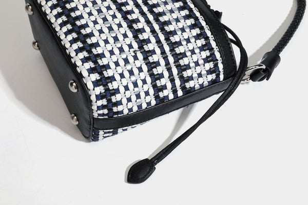 Small structured woven checker bucket bag with braided top handle, drawstring closure, and silver-tone hardware in black