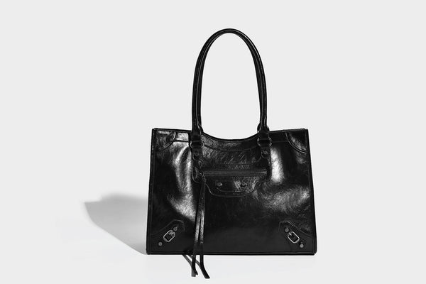 Large structured leather-look tote bag with front zip pocket, moto hardware accents, and long double shoulder straps, detail