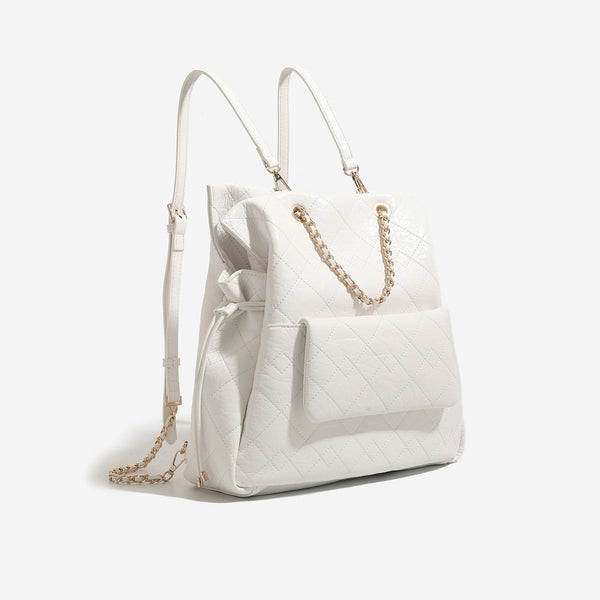 Large quilted leather-look drawstring backpack handbag with gold-tone chain handles and front flap pocket, detail view 6