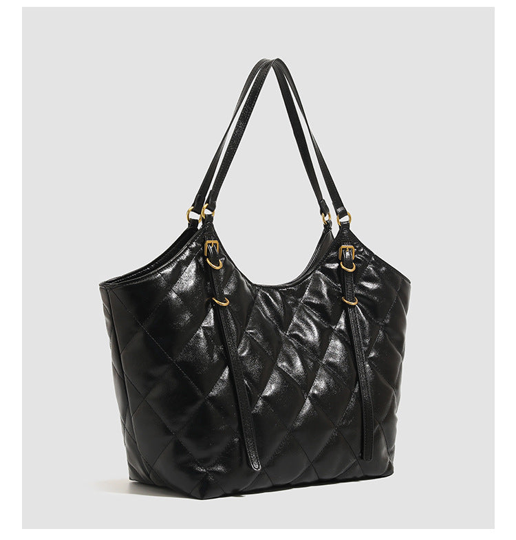 Large quilted diamond-pattern tote bag with glossy leather-look finish, dual flat shoulder straps, and gold-tone hardware