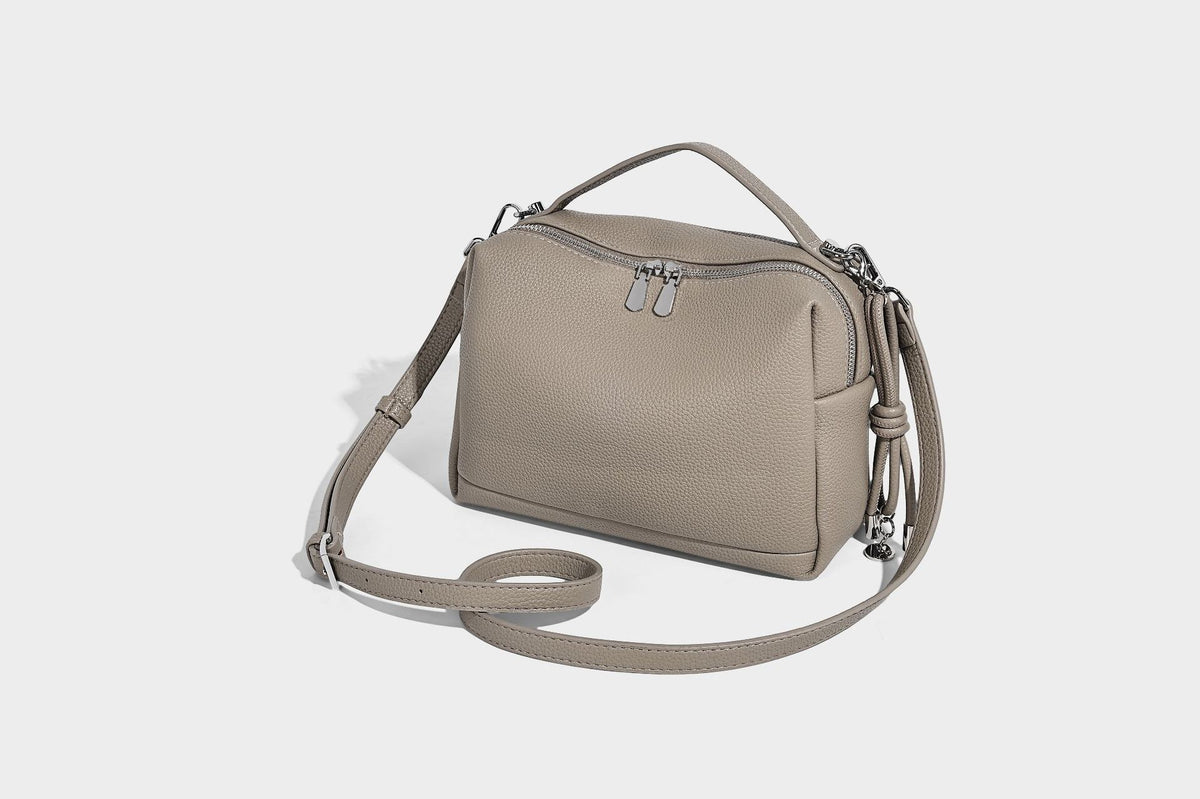 Kleine, strukturierte Crossbody-Tasche mit genarbter Oberfläche, Henkel, Reißverschluss, silberfarbener Hardware und optionalem Quastenanhänger