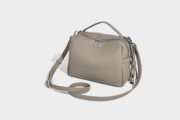 Kleine, strukturierte Crossbody-Tasche mit genarbter Oberfläche, Henkel, Reißverschluss, silberfarbener Hardware und optionalem Quastenanhänger