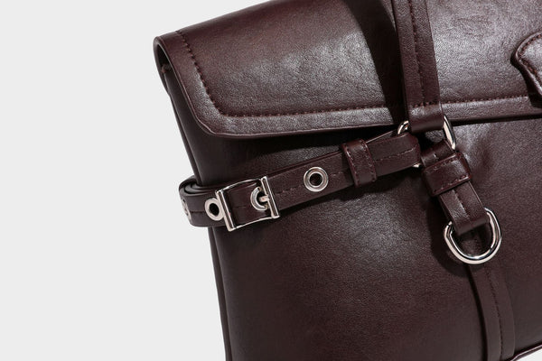 Strukturierte rechteckige Schultertasche mit Überschlagverschluss, vorderem Schnallengurt-Detail und ringförmigen Beschlägen in