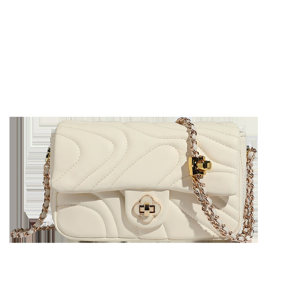 Compact cream quilted flap crossbody bag with wave stitching, gold-tone chain strap, and four-petal turn-lock clasp, detail