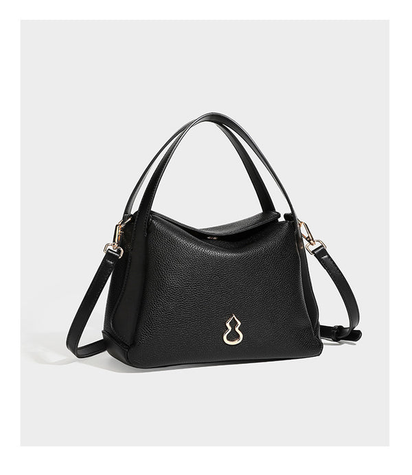 Structured pebbled leather-look shoulder bag with flap top, gold-tone emblem hardware, dual top handles, and detachable