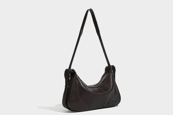 Slouchy crescent hobo shoulder bag in dark brown pebbled leather-look finish with zip top and long shoulder strap, detail