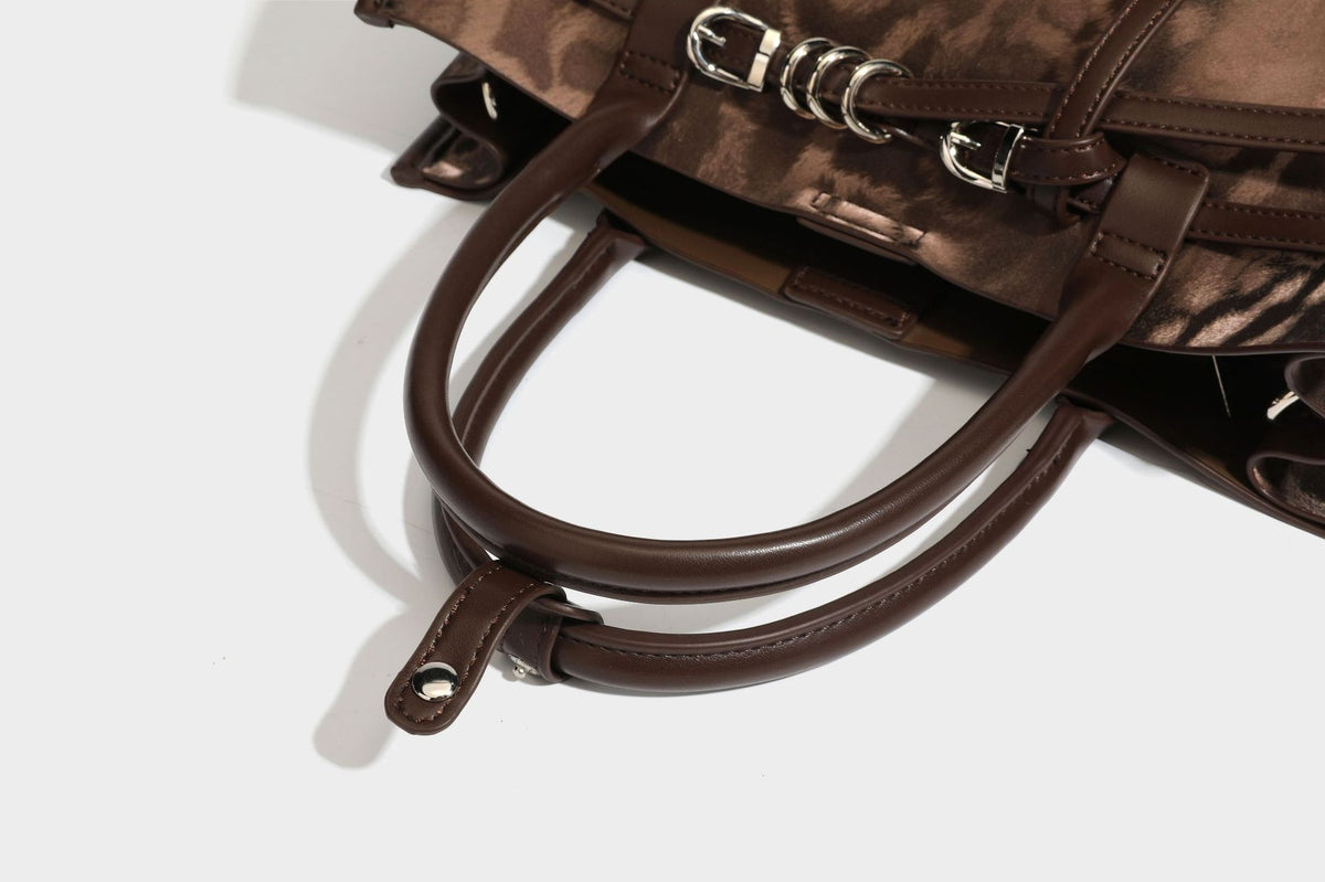 Structured leopard-print tote bag with glossy satin-like finish, dual rounded top handles, silver buckle-and-ring front