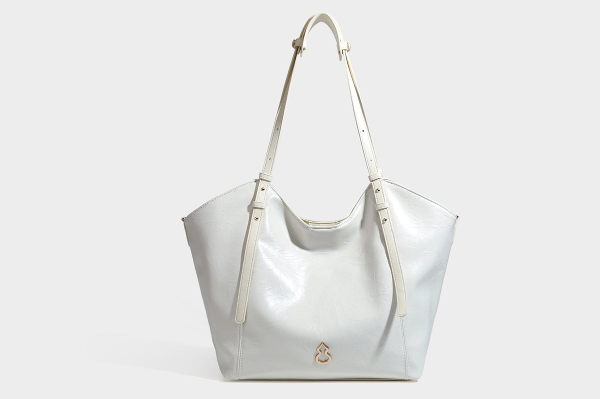 Große, glänzende Tote-Bag aus schwarzem Lederimitat mit geknitterter Optik, lässig fallender Trapezsilhouette, zwei Schulterriemen und goldfarbenen