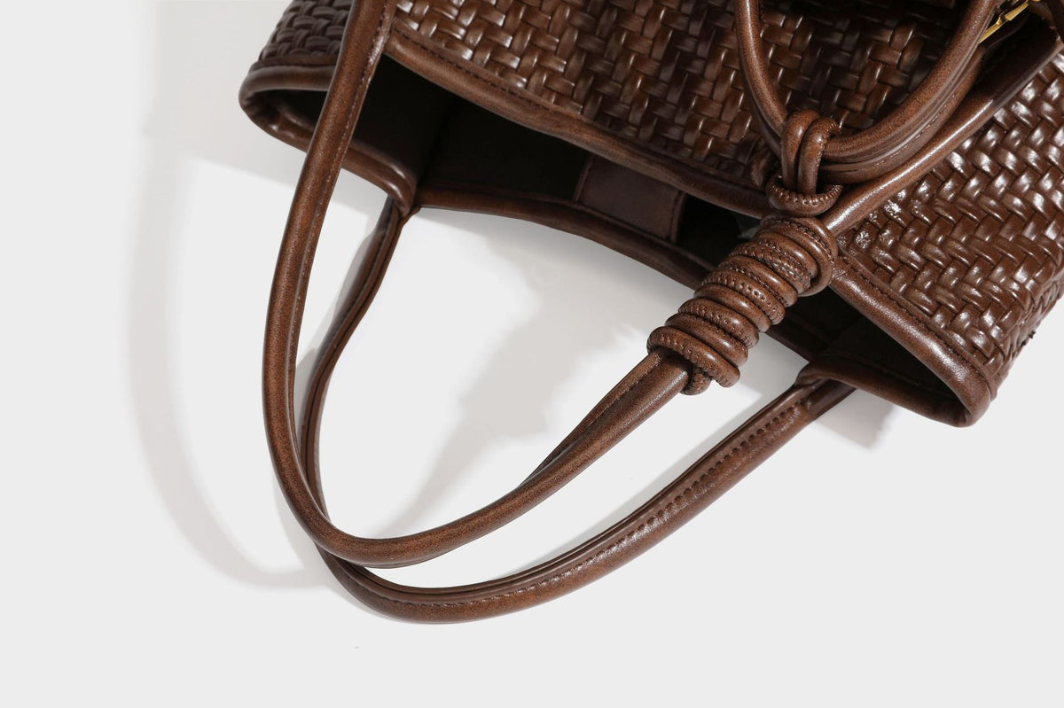 Strukturierte Tote-Bag mit Webstruktur in Braun, glattem Besatz in Lederoptik, geknoteten Henkeln und angehängtem Mini-Beutel mit Kordelzug