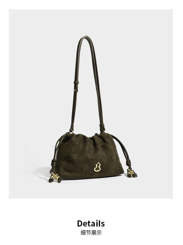 Suede-look drawstring shoulder bag in brown with smooth trim, knotted bead drawstring closure, slim adjustable strap, and