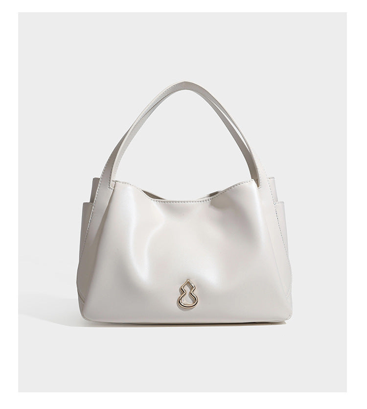 Structured glossy leather-look tote shoulder bag with dual top handles, detachable crossbody strap, side pockets, and, detail