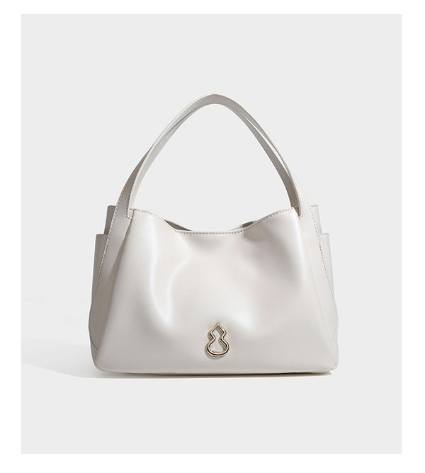 Structured glossy leather-look tote shoulder bag with dual top handles, detachable crossbody strap, side pockets, and, detail