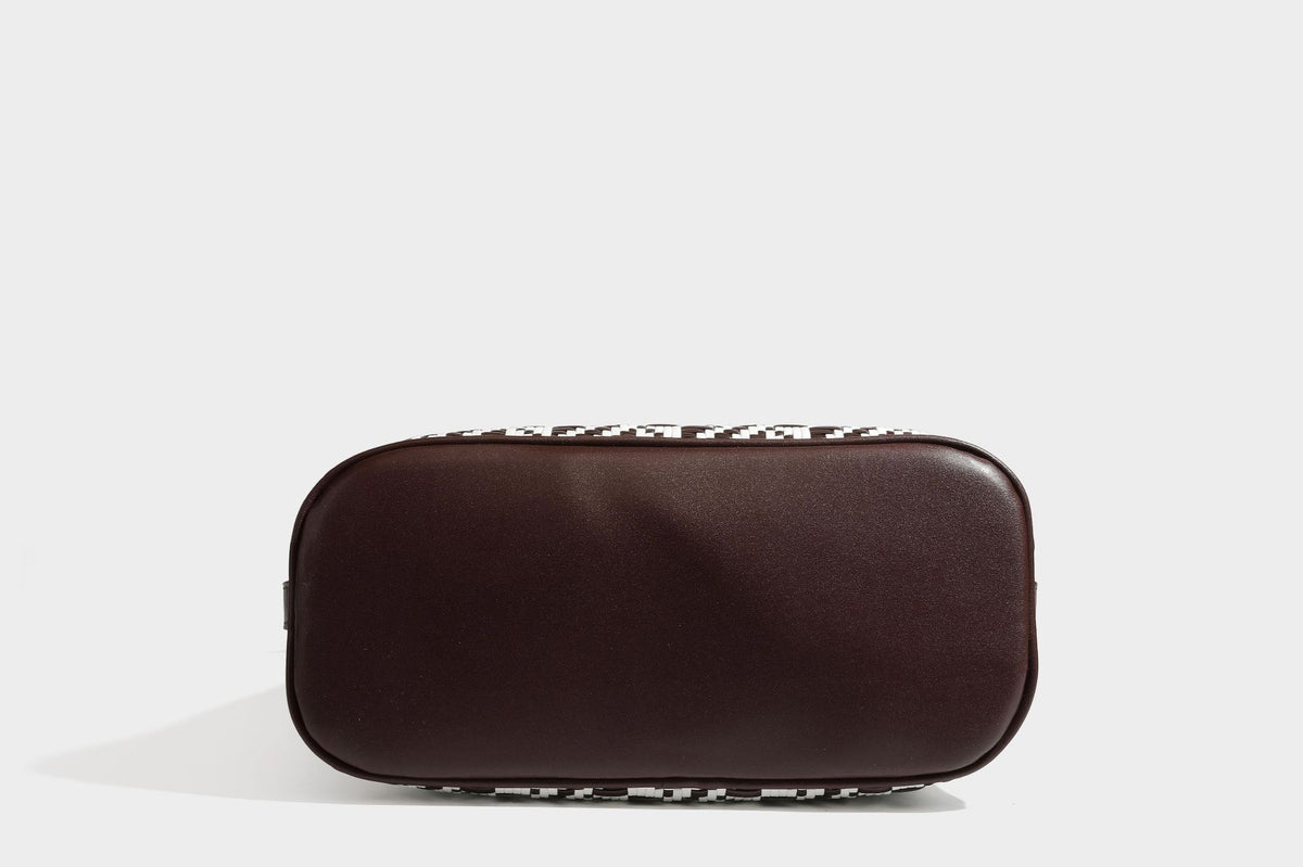 Woven geometric bucket shoulder bag in white and dark brown two-tone pattern with leather-look trim and drawstring top
