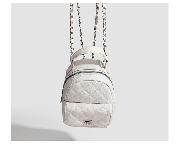 Compact diamond-quilted mini backpack handbag with silver-tone chain straps and turn-lock front pocket, detail view 13