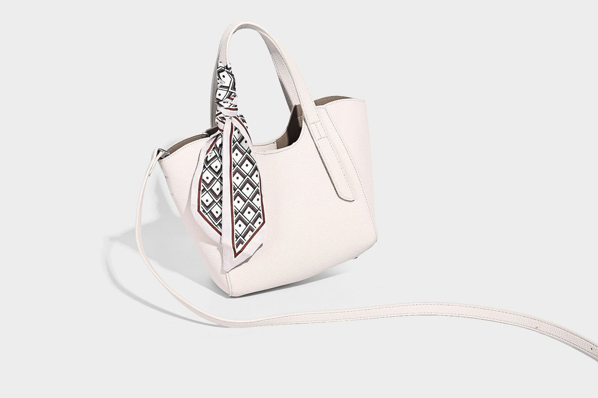 Structured pebbled leather-look tote bag with detachable scarf tie, dual top handles, and adjustable crossbody strap, detail