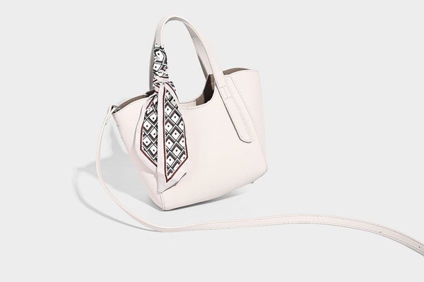 Structured pebbled leather-look tote bag with detachable scarf tie, dual top handles, and adjustable crossbody strap, detail