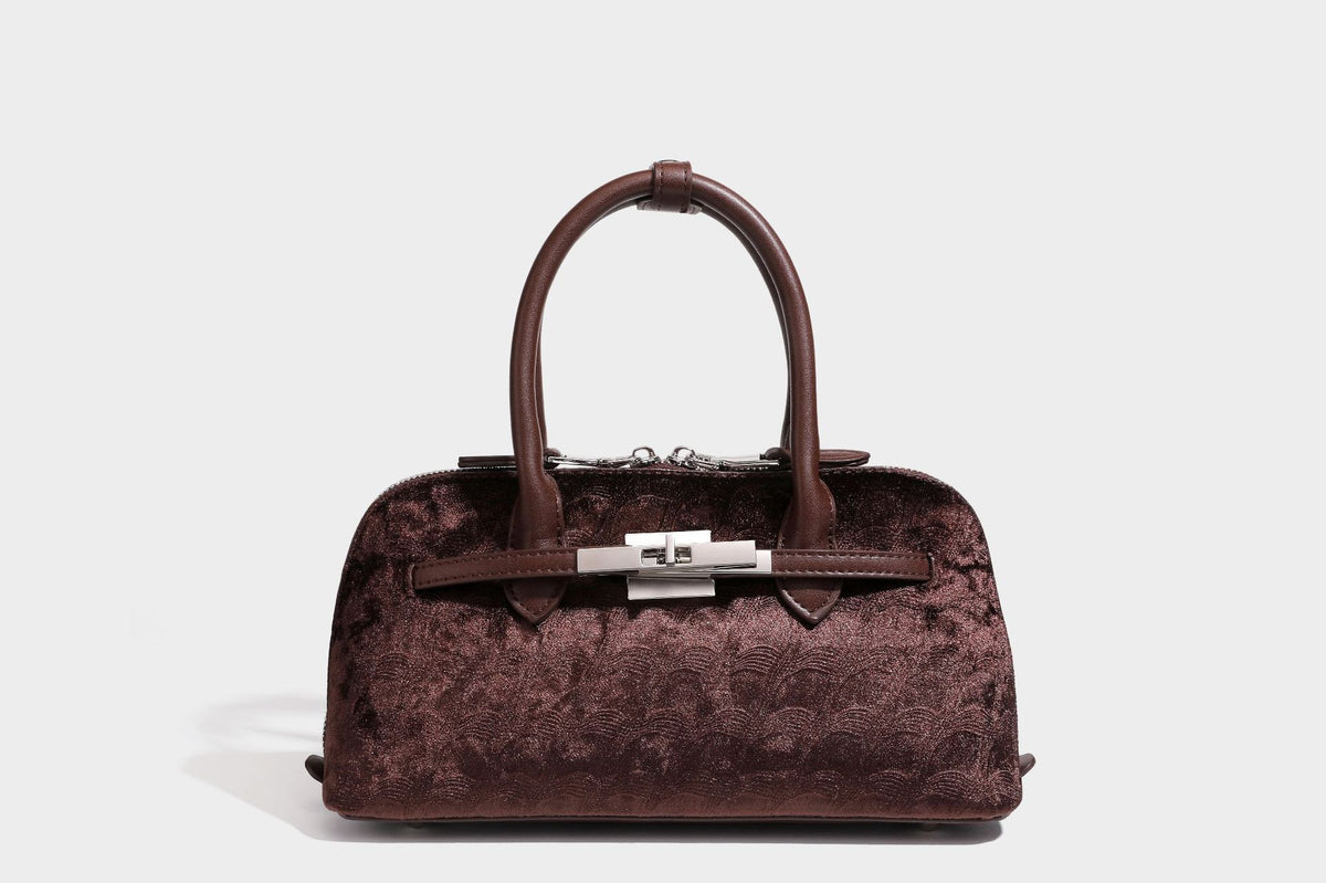 Small structured satchel bag in dark brown velvet-like textured finish with leather-look trim, silver-tone turn-lock bar