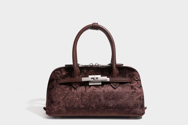Small structured satchel bag in dark brown velvet-like textured finish with leather-look trim, silver-tone turn-lock bar