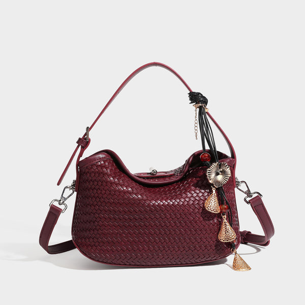 Small woven-look leather-look flap shoulder hobo bag in burgundy with silver-tone hardware and decorative tassel charm
